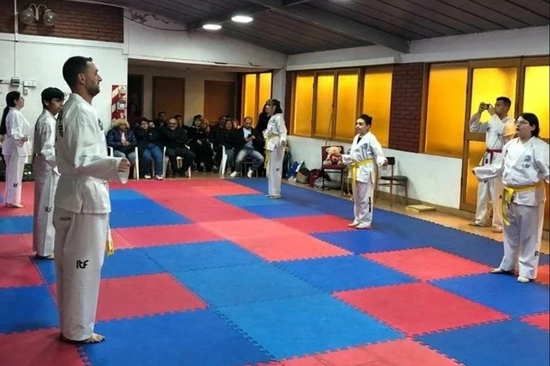 El dojo lleno durante una clase, con las familias mirando desde las sillas