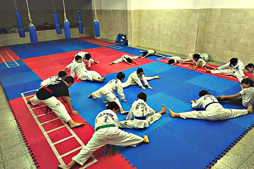 El grupo elongando sobre los tatamis antes de empezar la clase