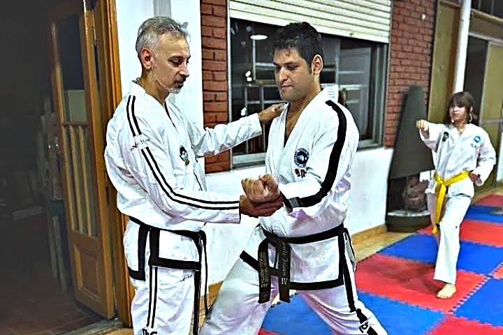 Dos cinturones negros practicando una técnica en el dojo